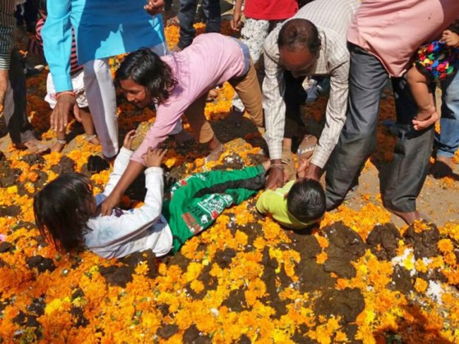 Индийский ритуал: родители бросают детей в навоз